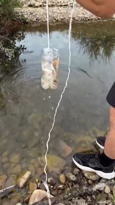 a person is standing in the water with a rope attached to their shoelaces