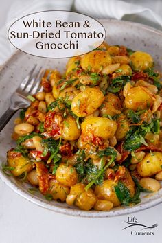 white bean and sun dried tomato gnocchini in a bowl with a fork