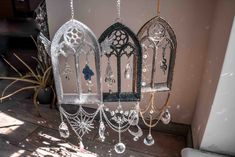 three birdcages are hanging from chains and decorated with crystal beads, crystals and pearls