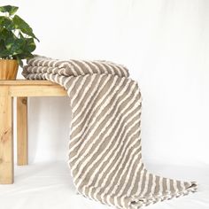 a table with a potted plant on top of it and a blanket draped over it