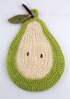 a crocheted bag with a green and white pear on it's side