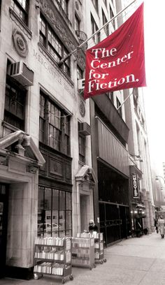 a red banner hanging from the side of a tall building