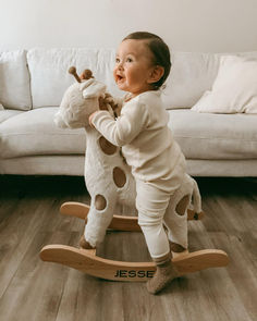 a baby is playing with a rocking horse