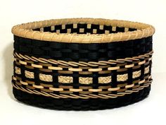 two black and brown baskets sitting next to each other on top of a white surface