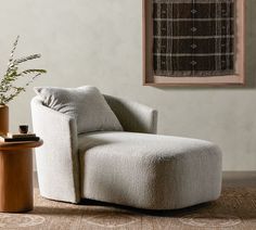 a living room with a chair, table and potted plant on the floor next to it