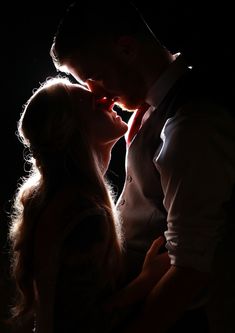 a man and woman kissing in the dark