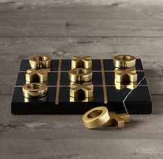 a black and gold board game set on top of a wooden table with dices