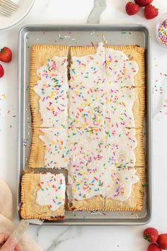 someone cutting into a pastry with white frosting and sprinkles on it