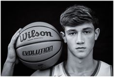 a young man holding a basketball in front of his face with the words wilson on it