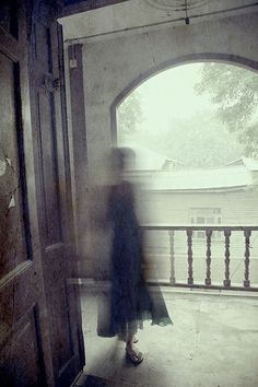 a blurry photo of a woman walking into an open door