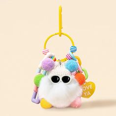 a white stuffed animal with lots of colorful decorations on it's head and eyes