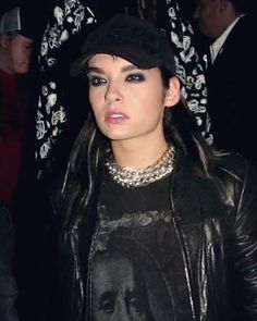 a woman wearing a black hat and leather jacket