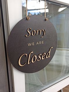 a sign that says sorry we are closed hanging from the side of a building door