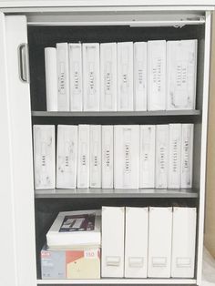 a book shelf filled with lots of books and binders on top of each other