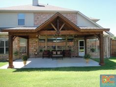 a patio covered in wood and surrounded by grass