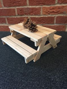 a wooden picnic table with a pine cone on top