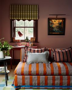 a living room filled with furniture and a painting on the wall next to a window