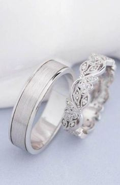 two white gold wedding rings with diamonds on top and the bottom one is made out of silver