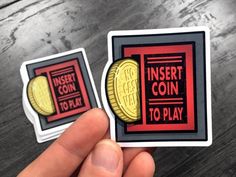 two stickers that say insert coin to play and insert coin to play on them