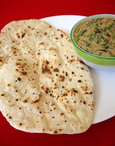 two flat breads on a plate with a bowl of dip