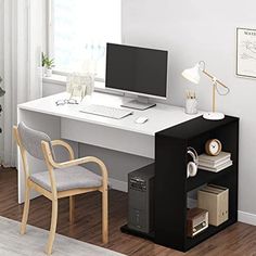 a desk with a computer on top of it and a chair next to it in front of a window