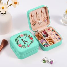 an open jewelry box sitting on top of a table next to flowers and other accessories