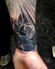 a black and white rose tattoo on the arm