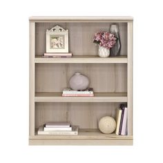 the bookcase has three shelves with books and vases on top of each shelf