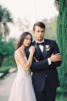 a man in a tuxedo standing next to a woman