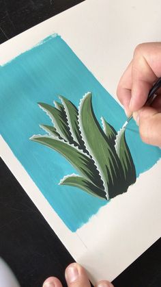 a person is painting a flower on paper