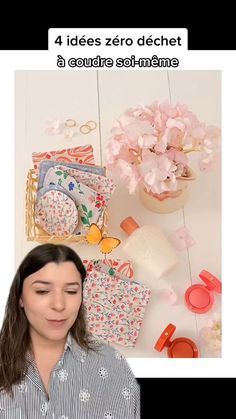 a woman standing in front of a table with flowers and other items on the table