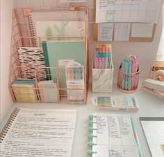 an organized desk with pens, pencils and paper