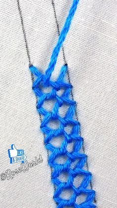 a blue crochet necklace is hanging on a white shirt