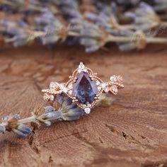 a close up of a ring on a piece of wood with flowers in the background