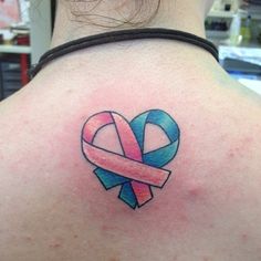 a woman with a tattoo on her back has a pink and blue ribbon in the shape of a heart