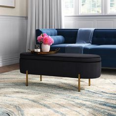 a living room with a blue couch, coffee table and flowers on the top of it