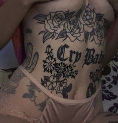 a woman with tattoos on her stomach and chest is holding a cell phone to her ear