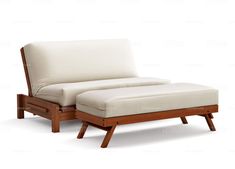 a white couch sitting on top of a wooden frame next to a footstool