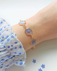 a close up of a person's arm wearing a bracelet with flowers on it