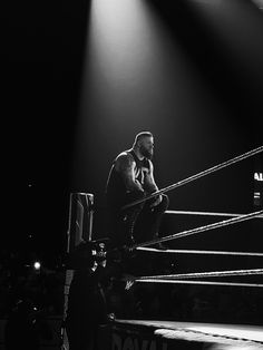 a man sitting on top of a wrestling ring