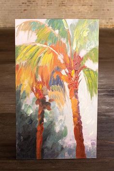 a painting of two palm trees on a wooden table