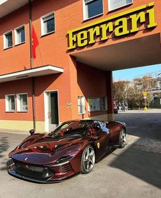 two sports cars are parked in front of a ferrari dealership with the word ferrari on it