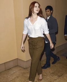 a woman in brown pants and white shirt