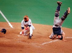 two baseball players are on the field during a game and one is falling to the ground