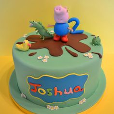a birthday cake with peppa the pig and other characters on it, sitting on top of a yellow table