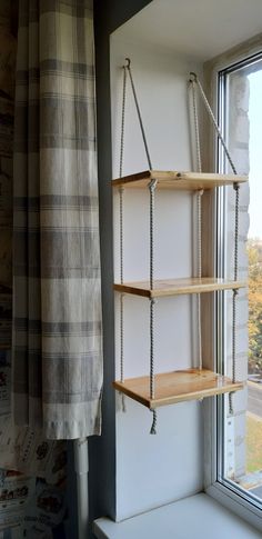 an empty shelf next to a window in a room with a plaid curtain on it