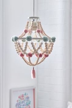 a white chandelier with beads and tassels hanging from it's ceiling