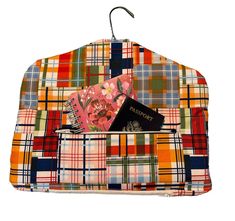 a multicolored plaid purse with a passport hanging from it's front pocket