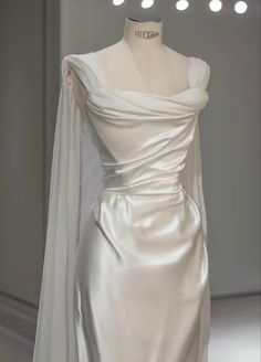 a white wedding dress on display in a room