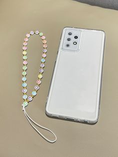 a phone case with a lanyard attached to it next to a beaded necklace